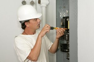 electrician working to replace a circuit breaker